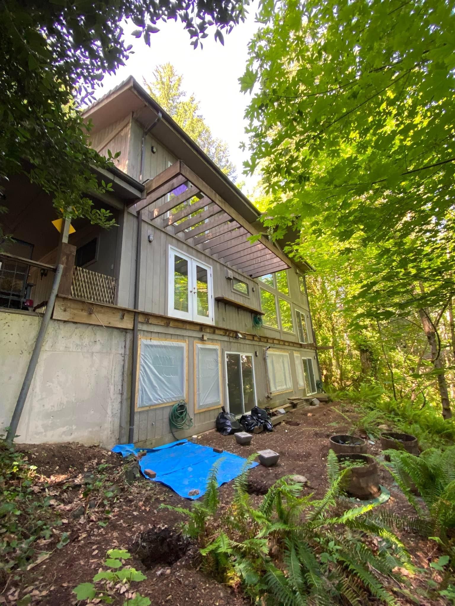 A large house is sitting on top of a hill in the middle of a forest.