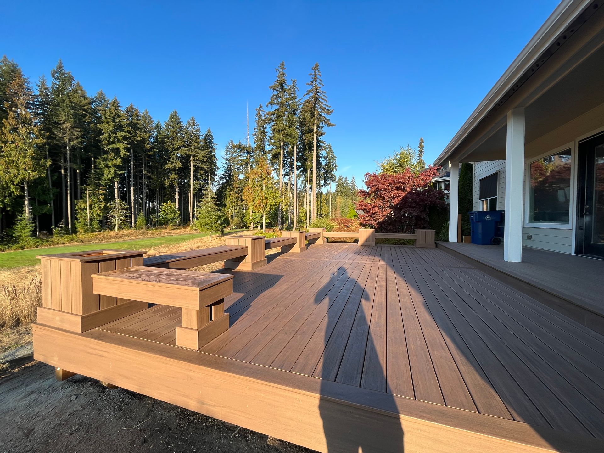 A wooden deck with a shadow of a person on it