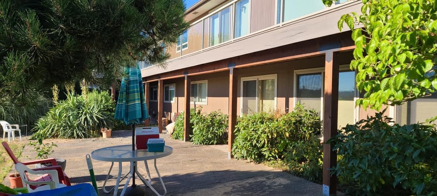 There is a table and chairs on the patio in front of the house.
