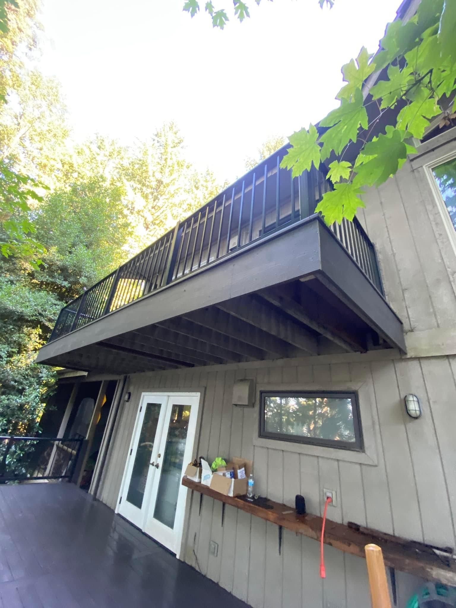A house with a large balcony on the side of it.