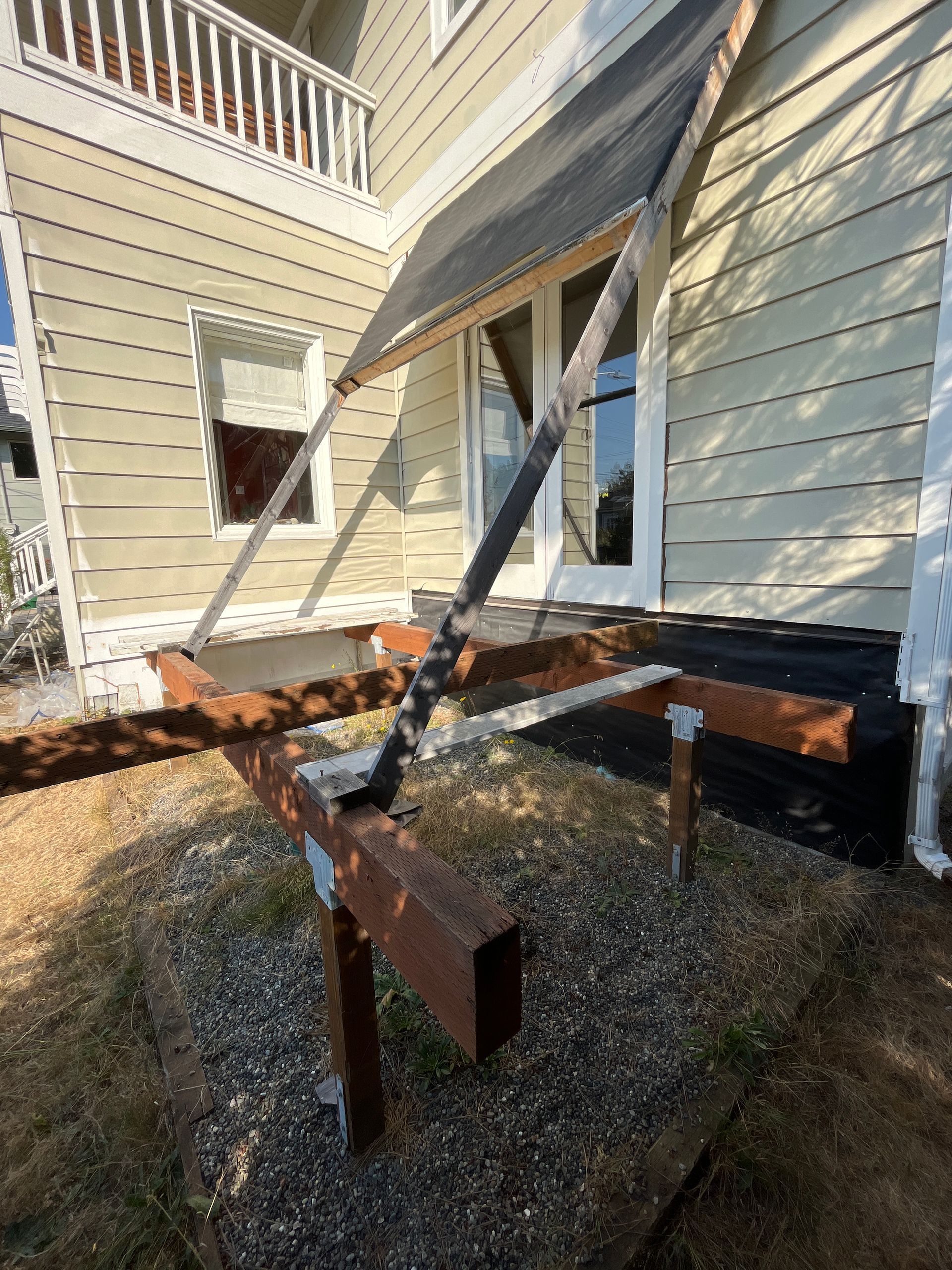 A wooden deck is being built in front of a house.