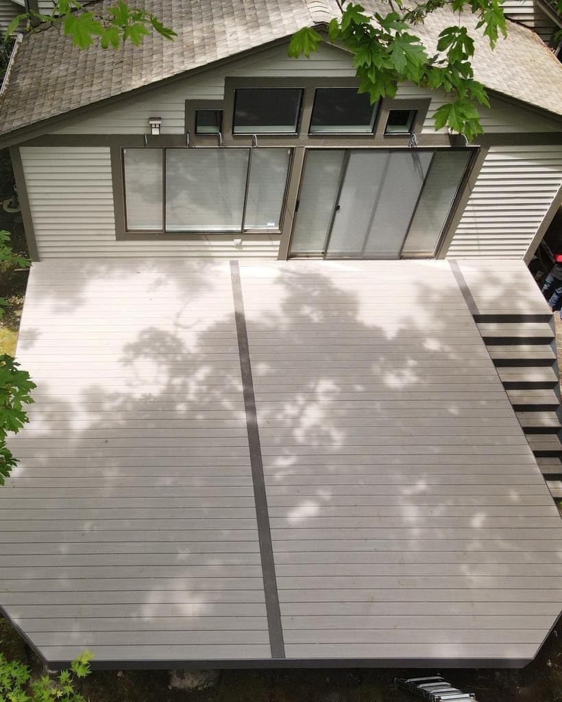 An aerial view of a house with a large deck in front of it.