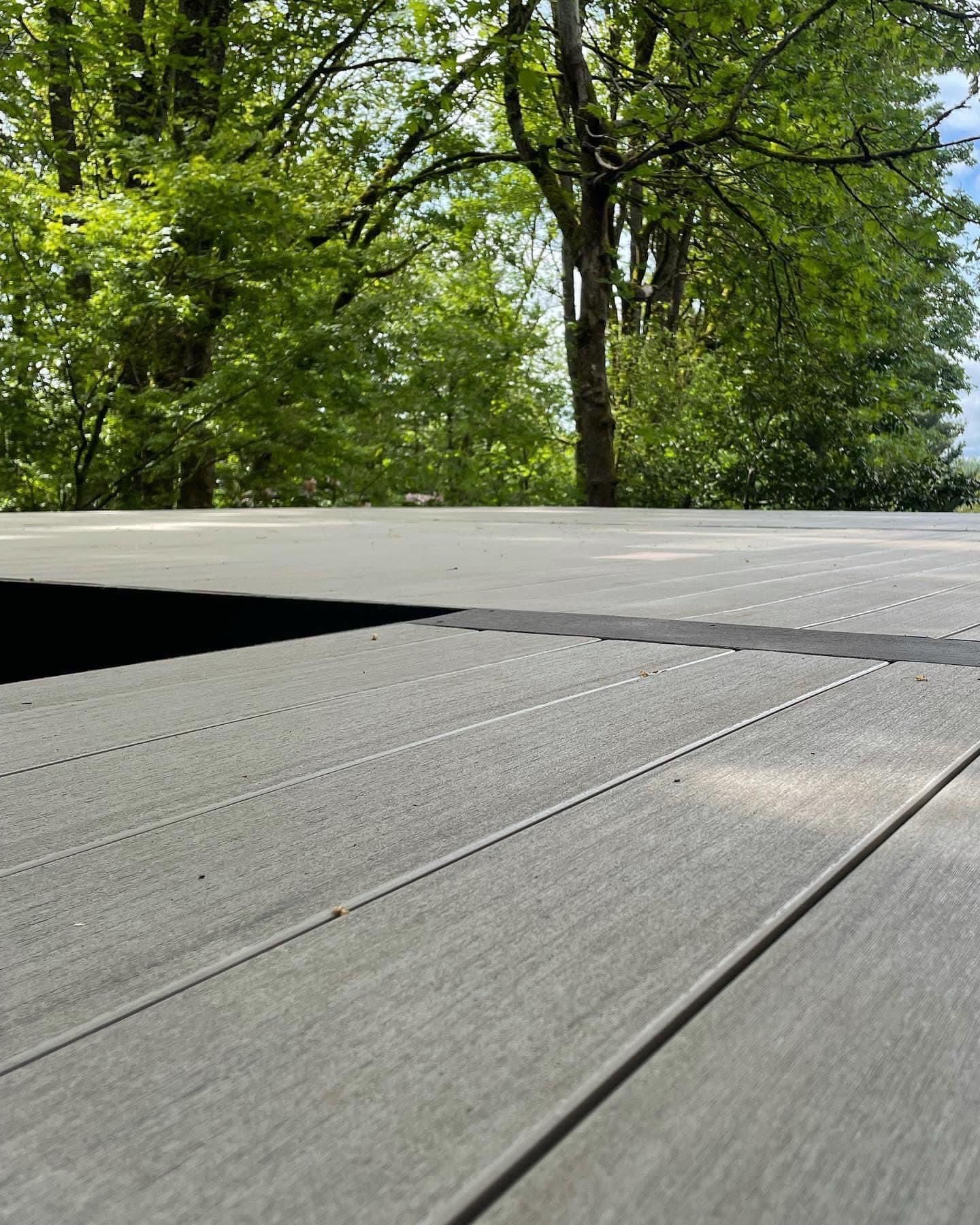 A wooden deck with trees in the background.