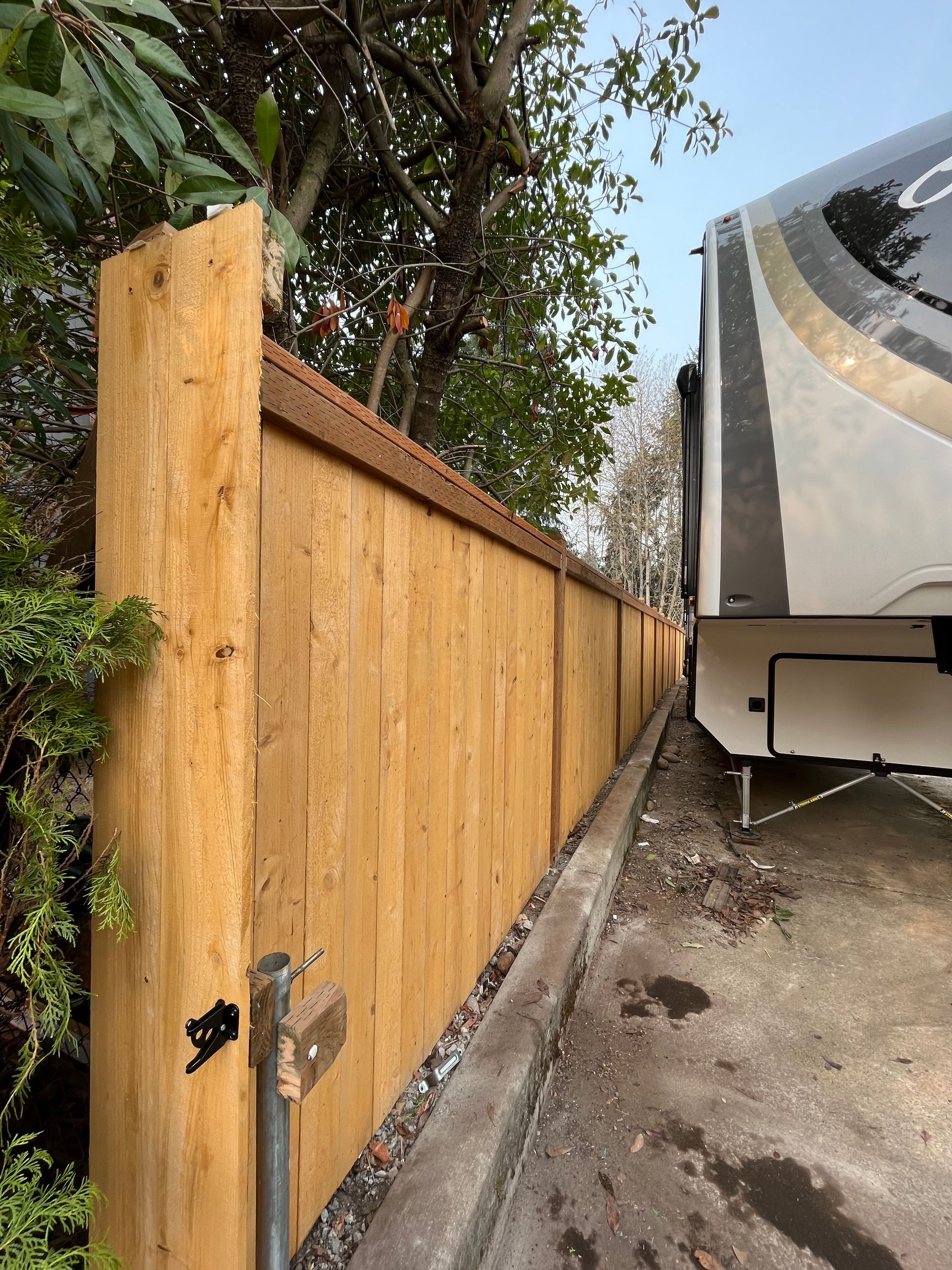A wooden fence with a trailer parked behind it.