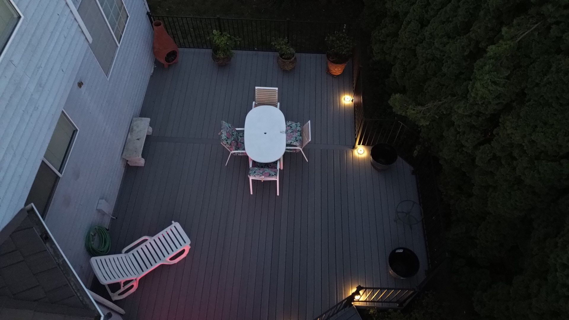 An aerial view of a deck with a table and chairs at night.