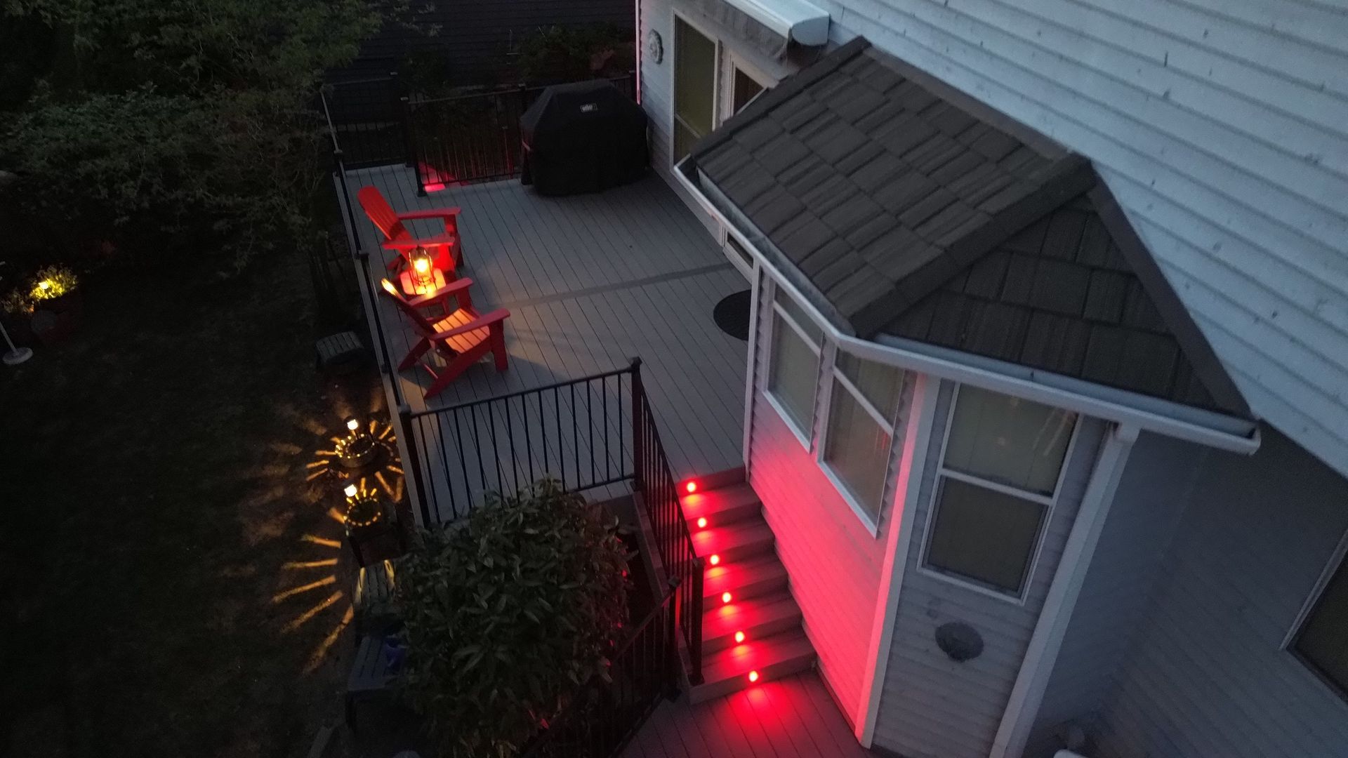 An aerial view of a house with red lights on the porch.