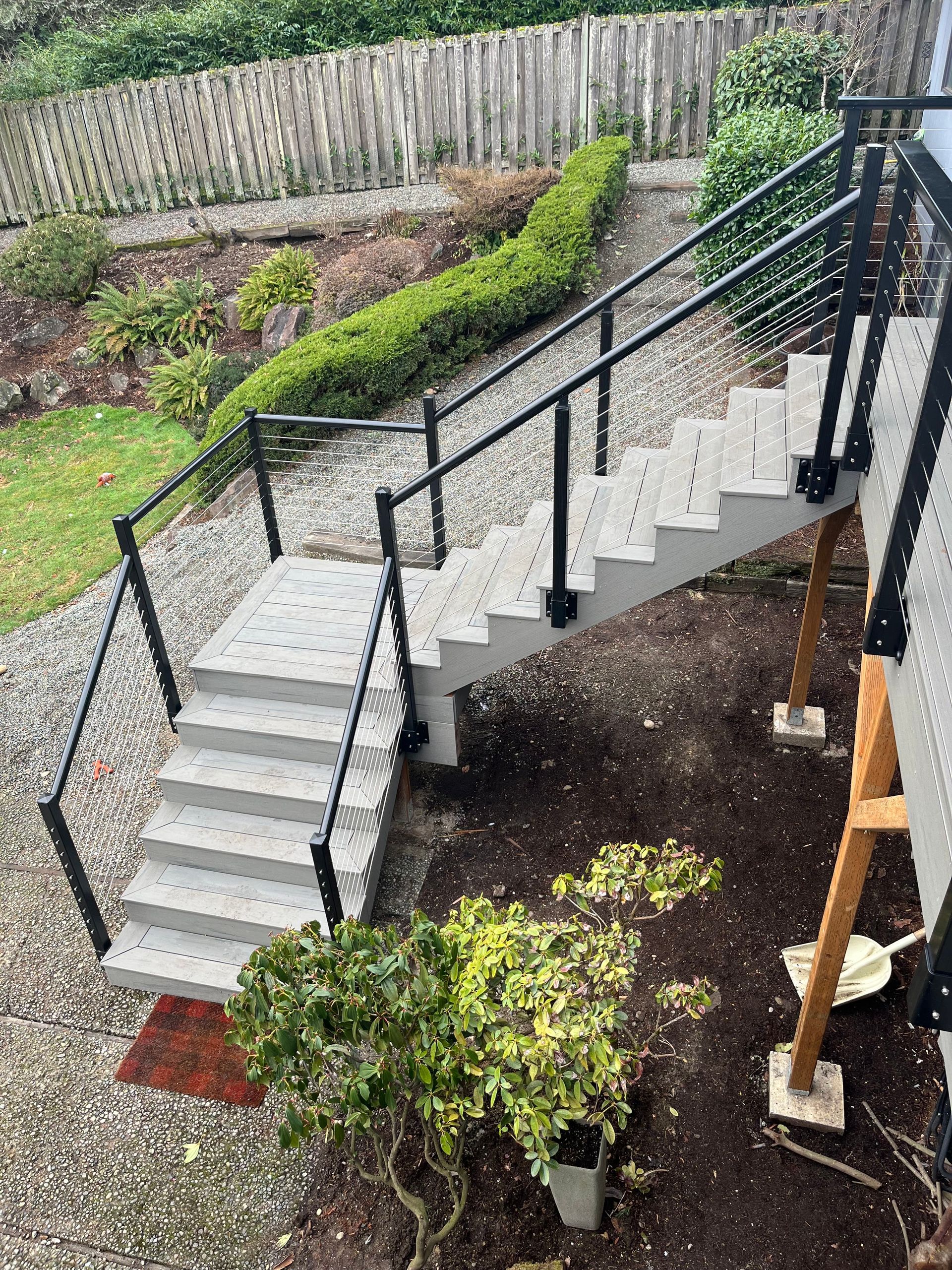 A set of stairs leading up to a deck with a metal railing.
