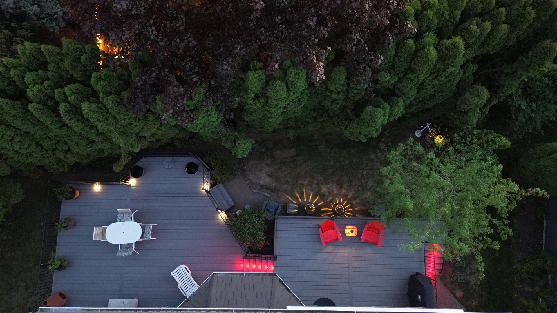 An aerial view of a deck with a table and chairs surrounded by trees.