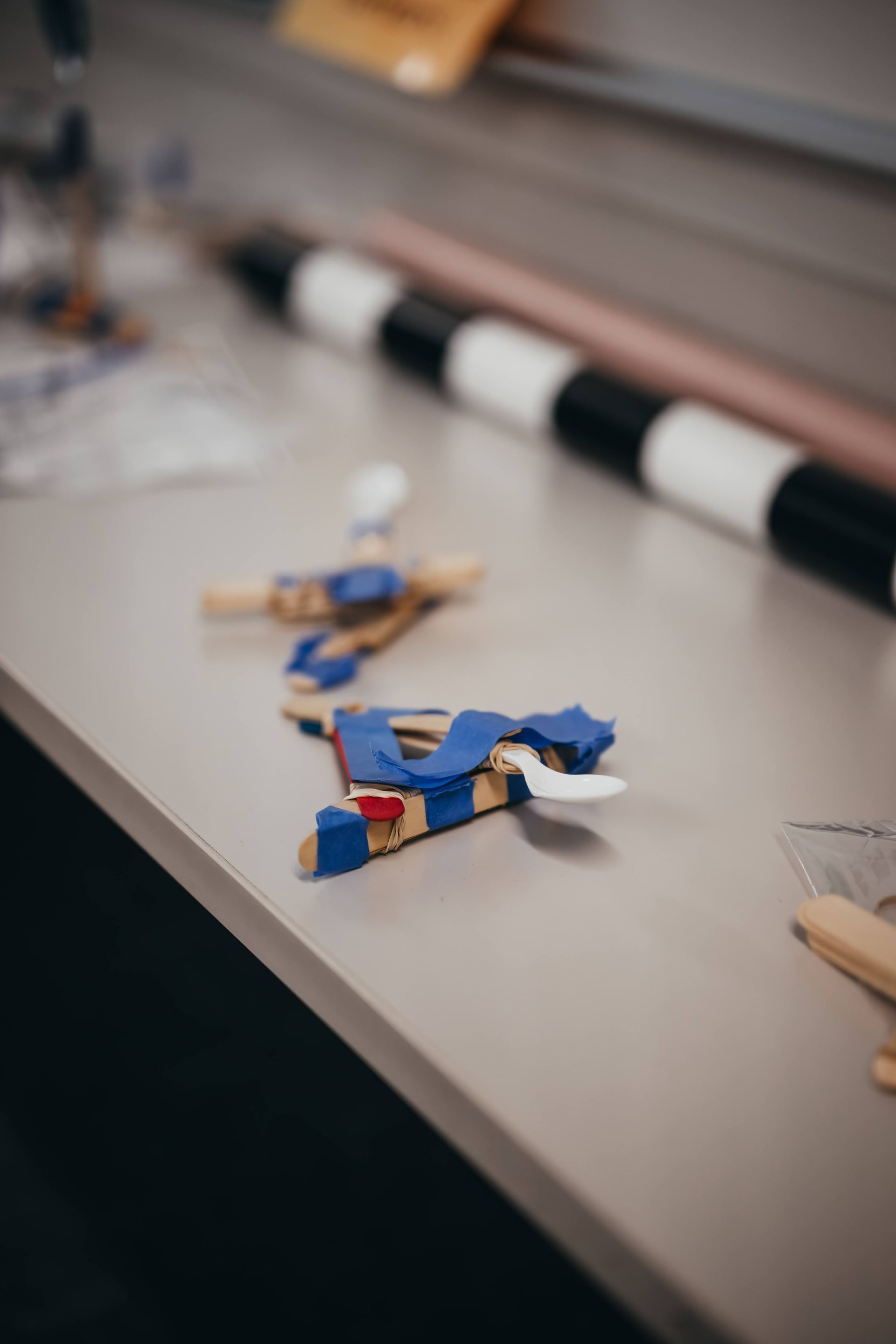 Wooden toy airplane on a table with a black and white striped object in the background.