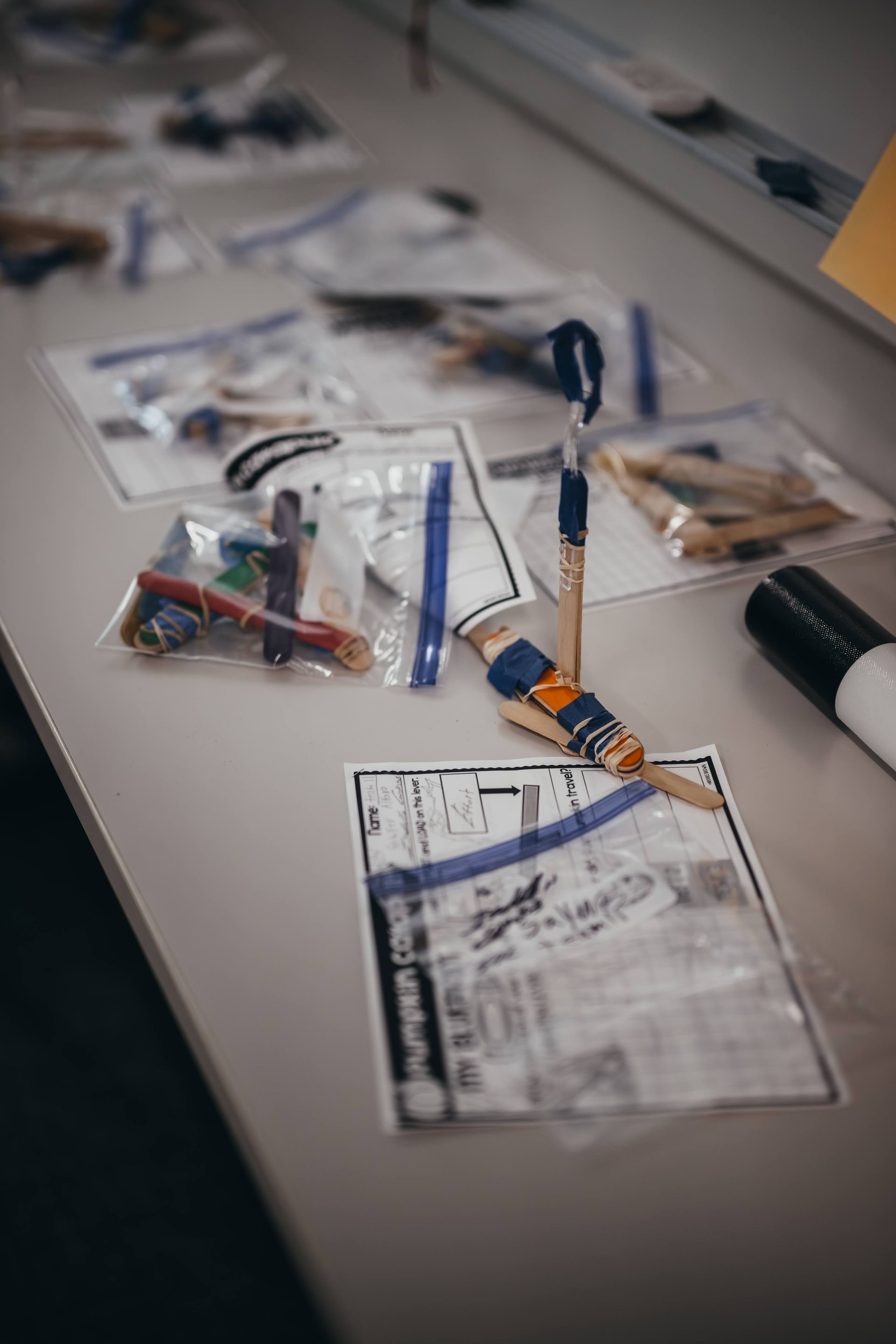 Evidence bags on a table, including documents, pens, and small items, possibly for a crime investigation.
