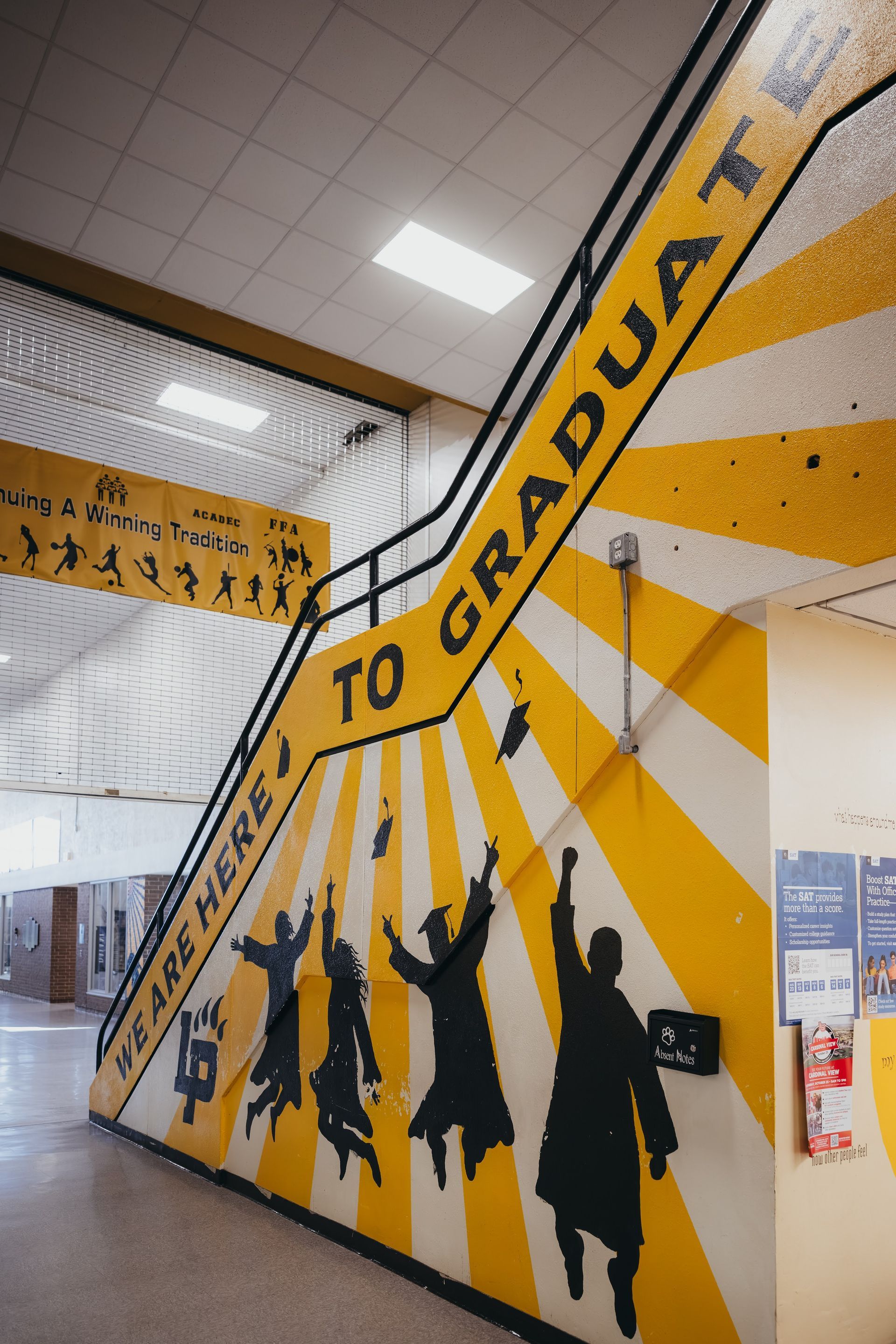 Mural of graduating figures in black silhouettes