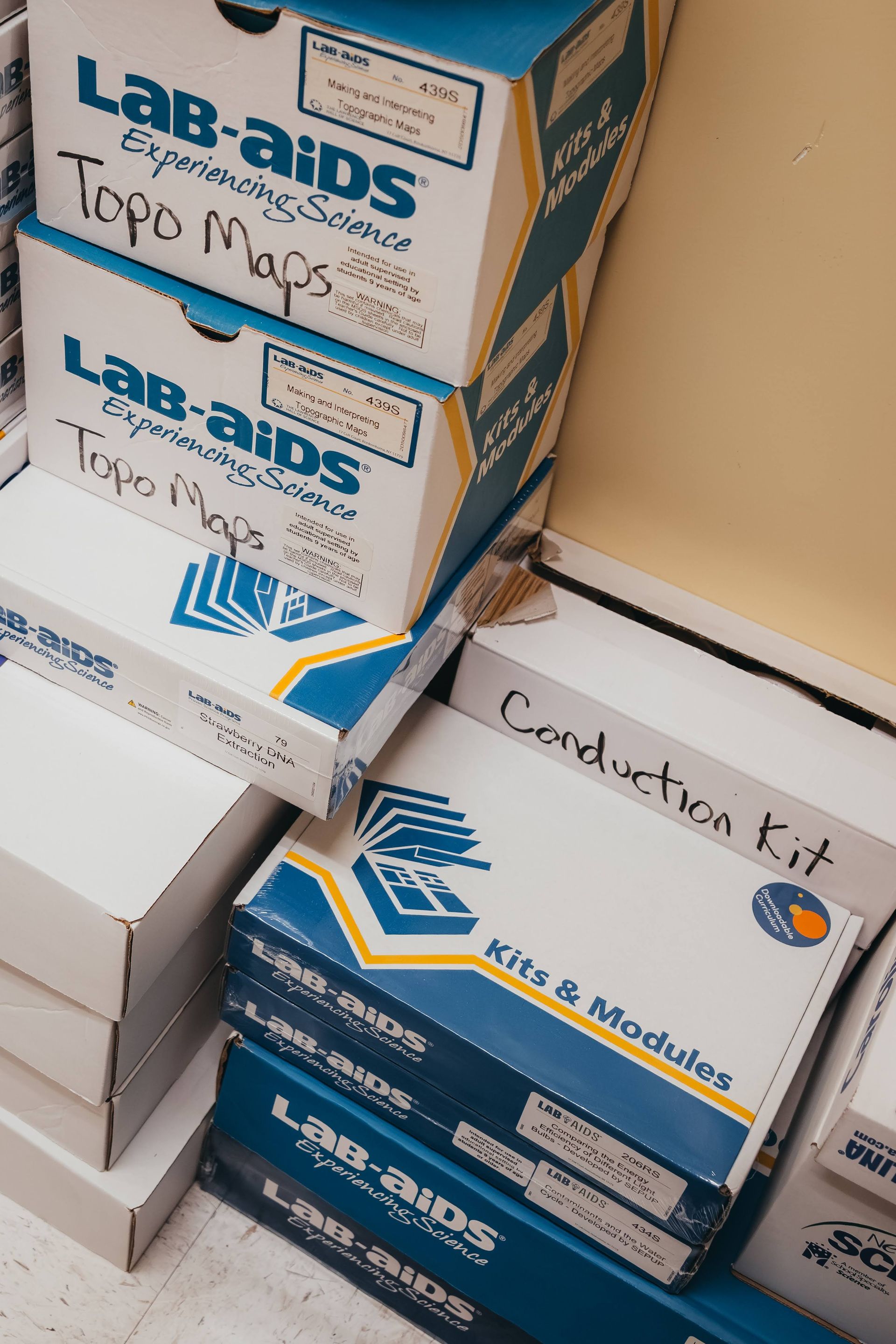 Boxes of educational science kits stacked on a shelf