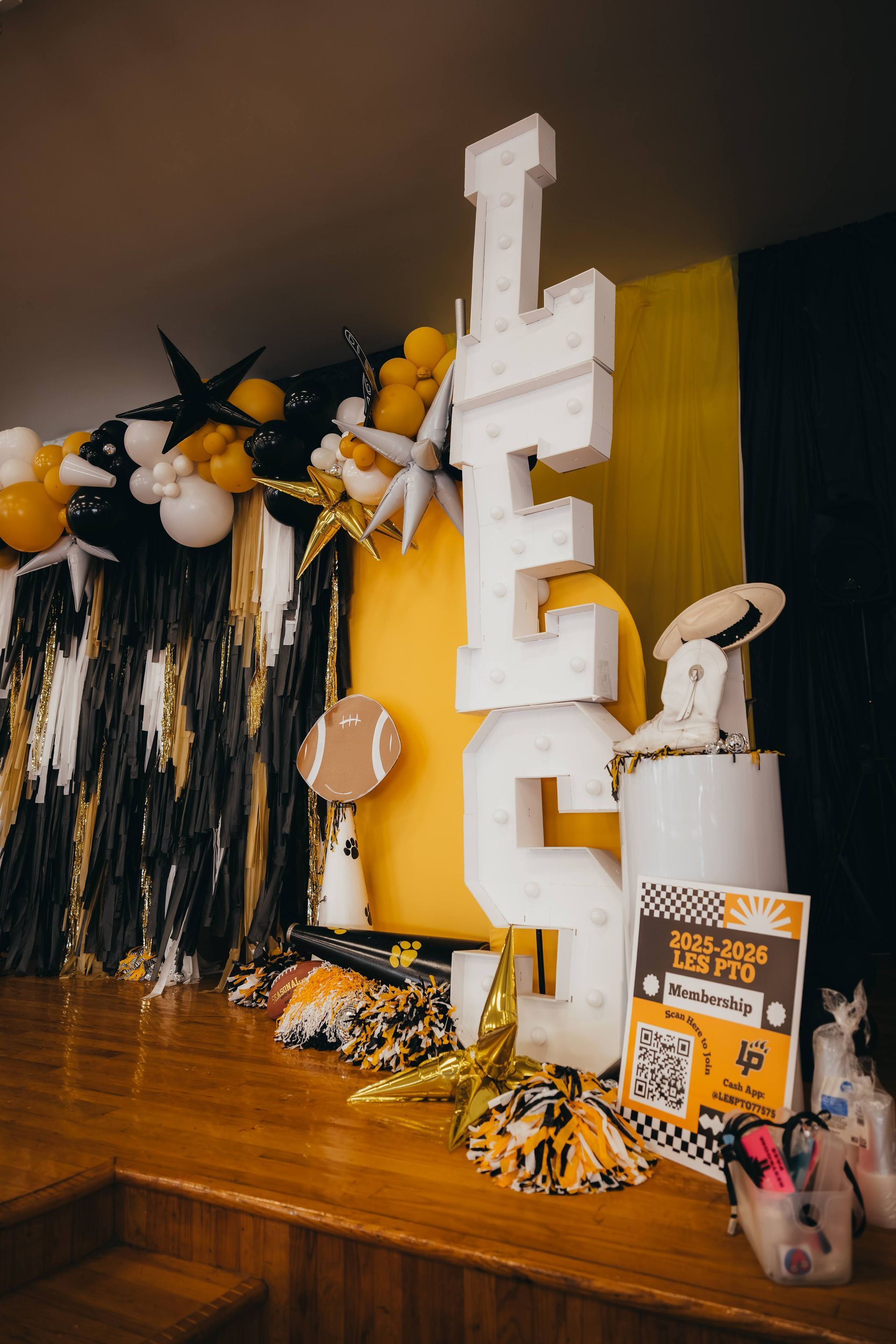 Party decorations with LFC letters, yellow and black balloons, football, and sign.