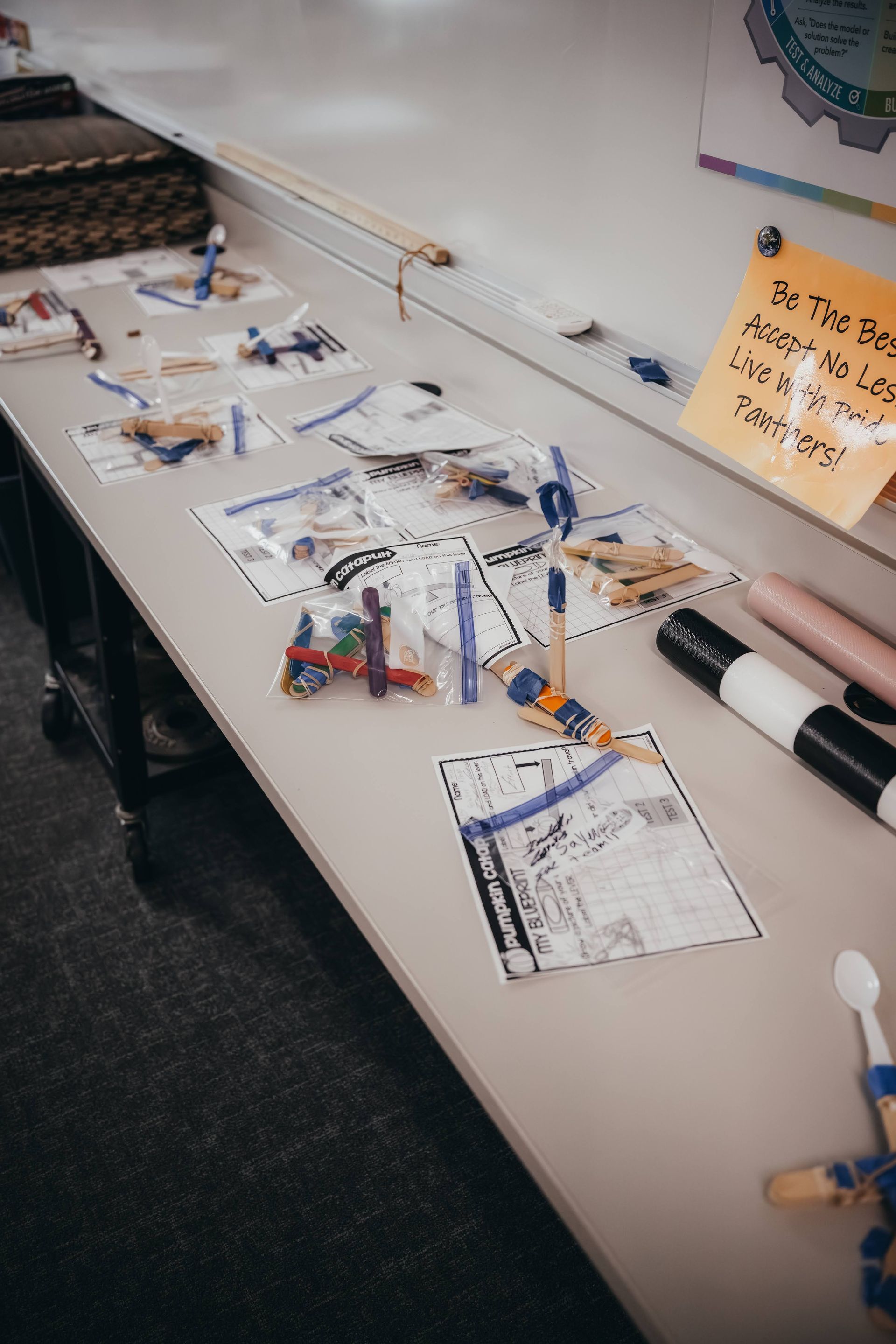 Table with bags of craft supplies, markers, and instructions for a project.