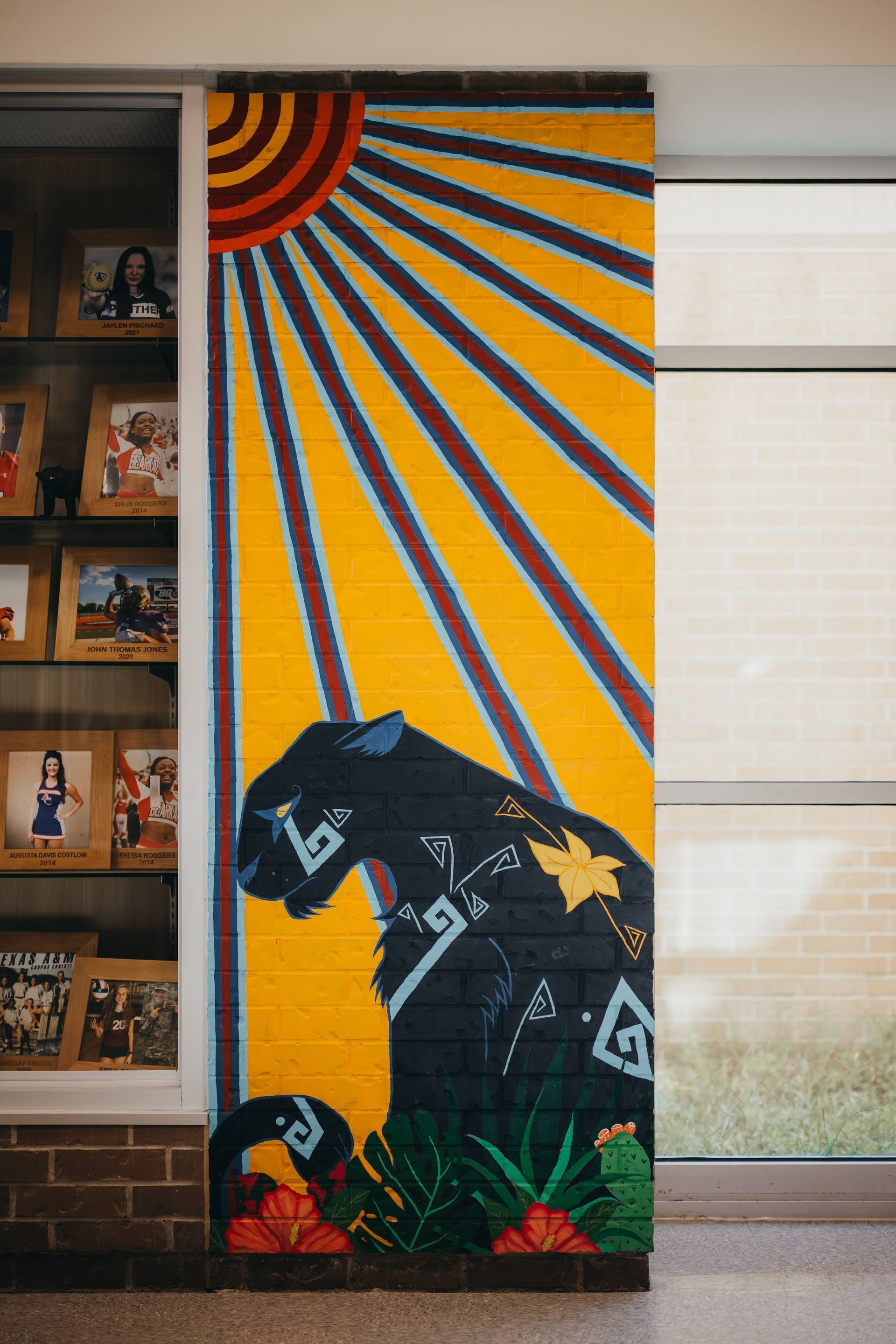 Mural of black panther under a radiating sun on a brick pillar