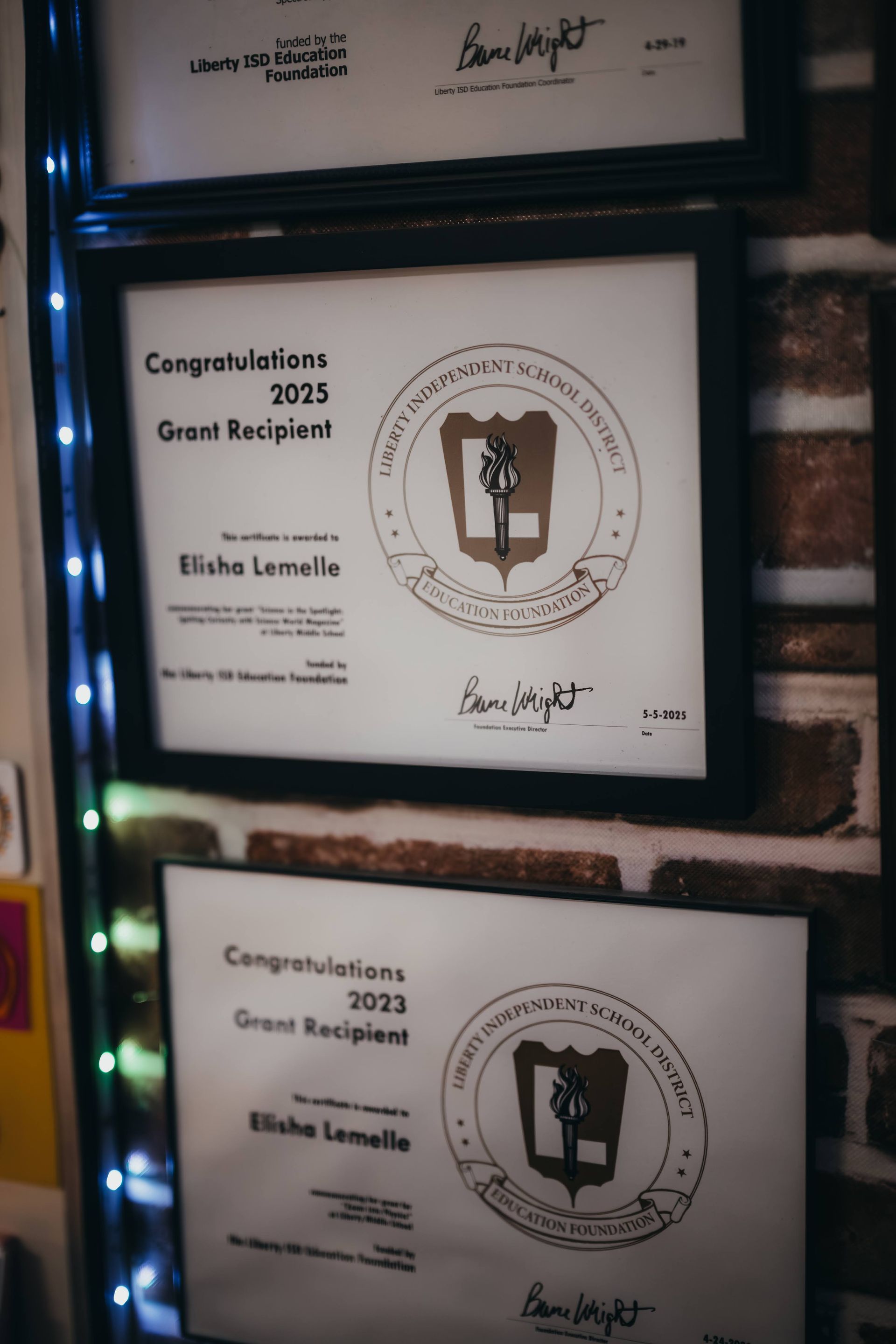 Framed certificates on brick wall