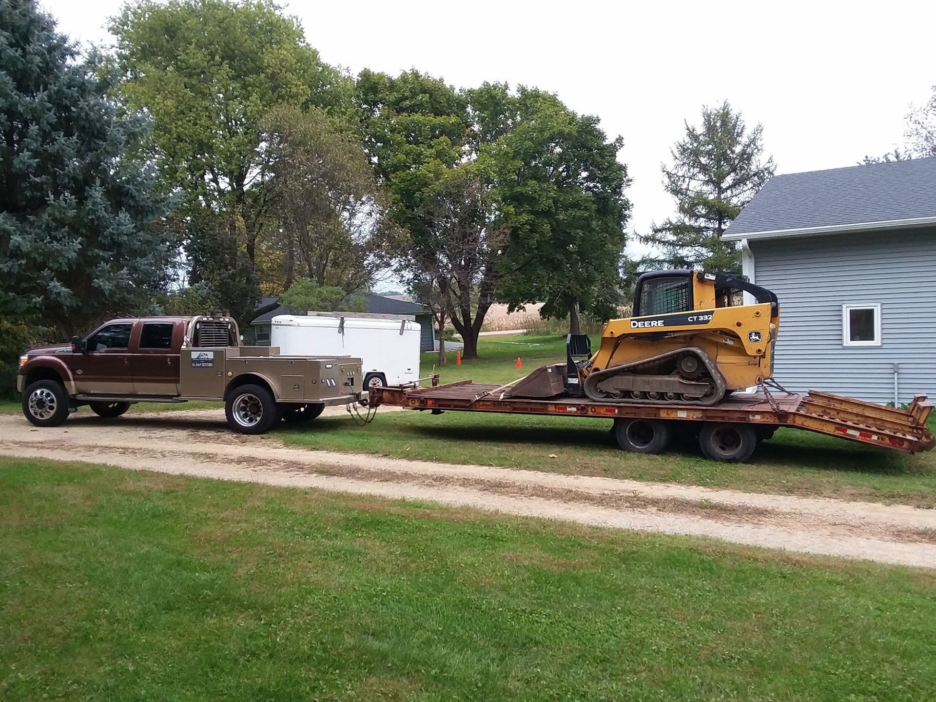 truck-and-skid-loader-in-a-residential-yard