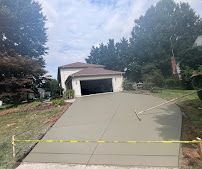Cracked sloped driveway blocked by yellow caution tape leading to a house garage