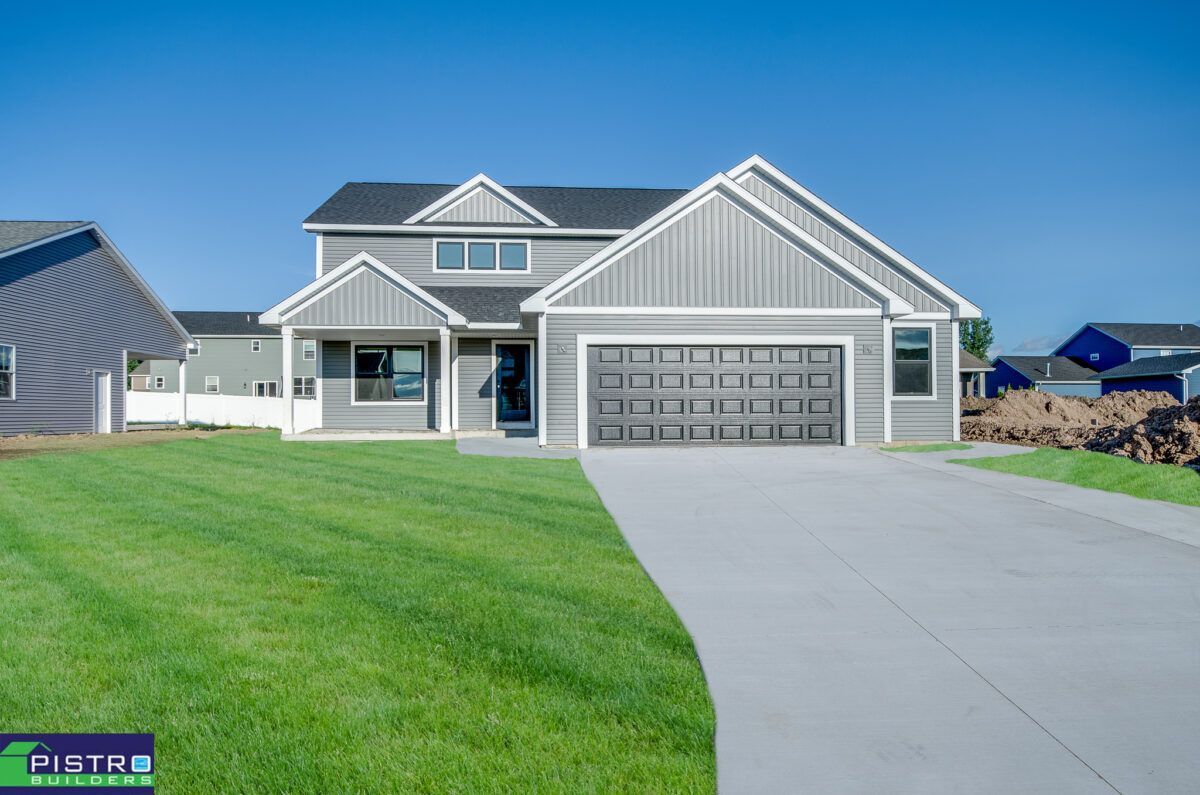 A large house with a garage and a driveway in front of it.
