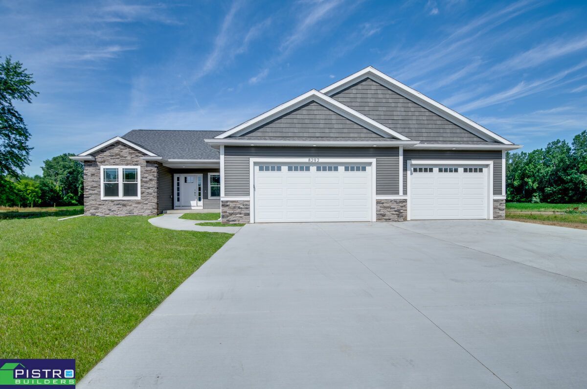 The front of a house with two garage doors and a concrete driveway.