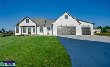 A large white house with two garages and a driveway