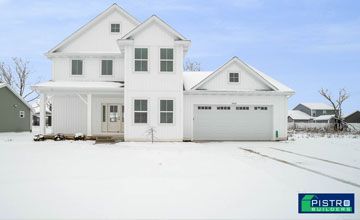 A white house with a garage in a snow