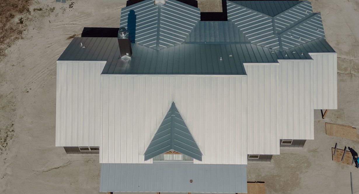 Overhead view of a house with a complex silver metal roof under construction