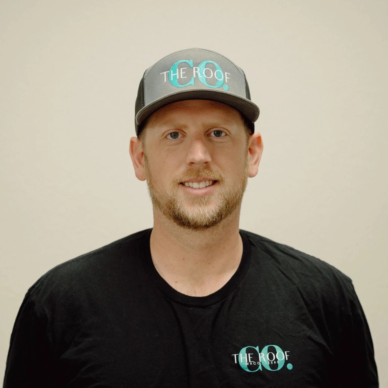 A man wearing a gray baseball cap and black shirt with 