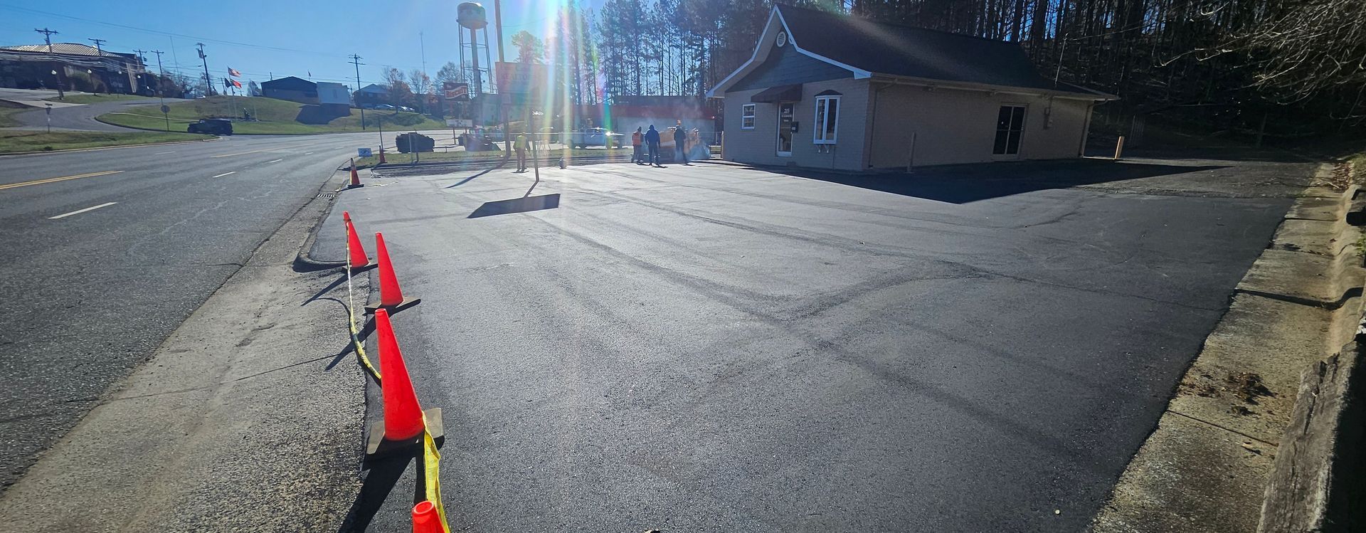 A row of orange cones are lined up on the side of a road.