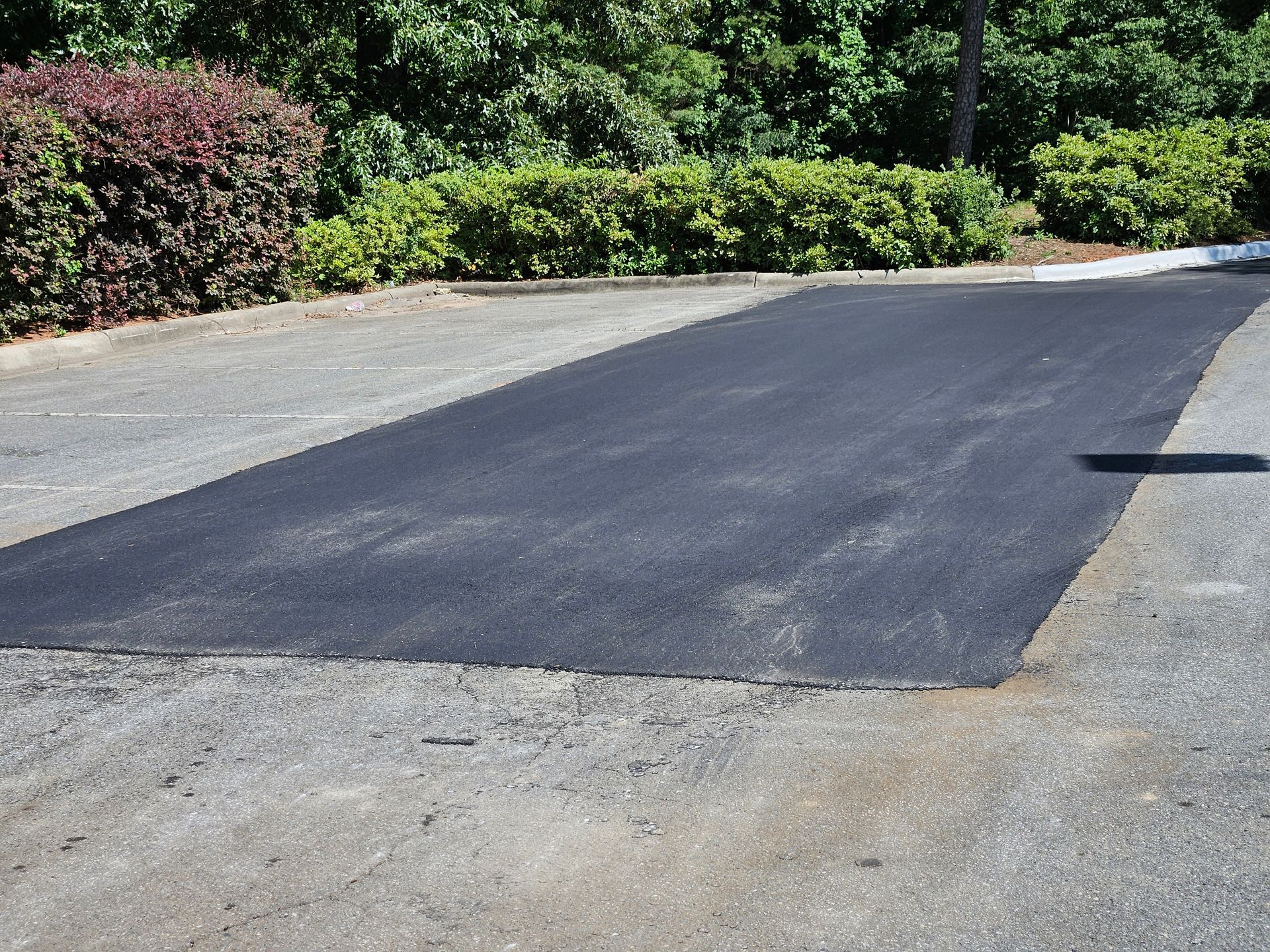 A large patch of black asphalt in a parking lot.