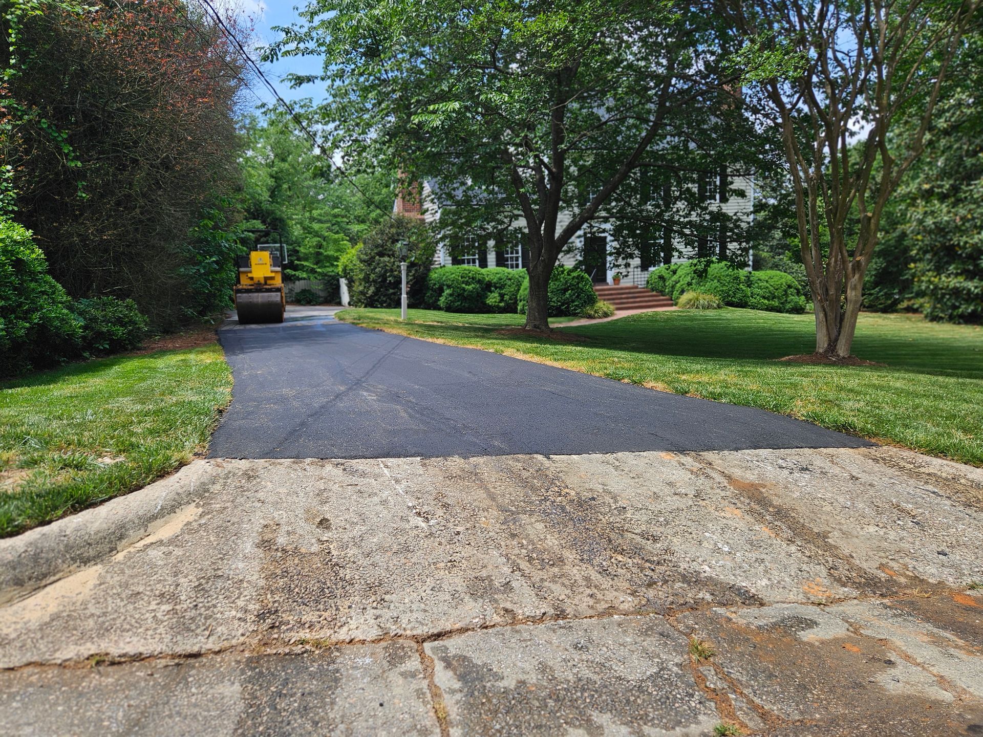 A driveway is being paved in front of a house.