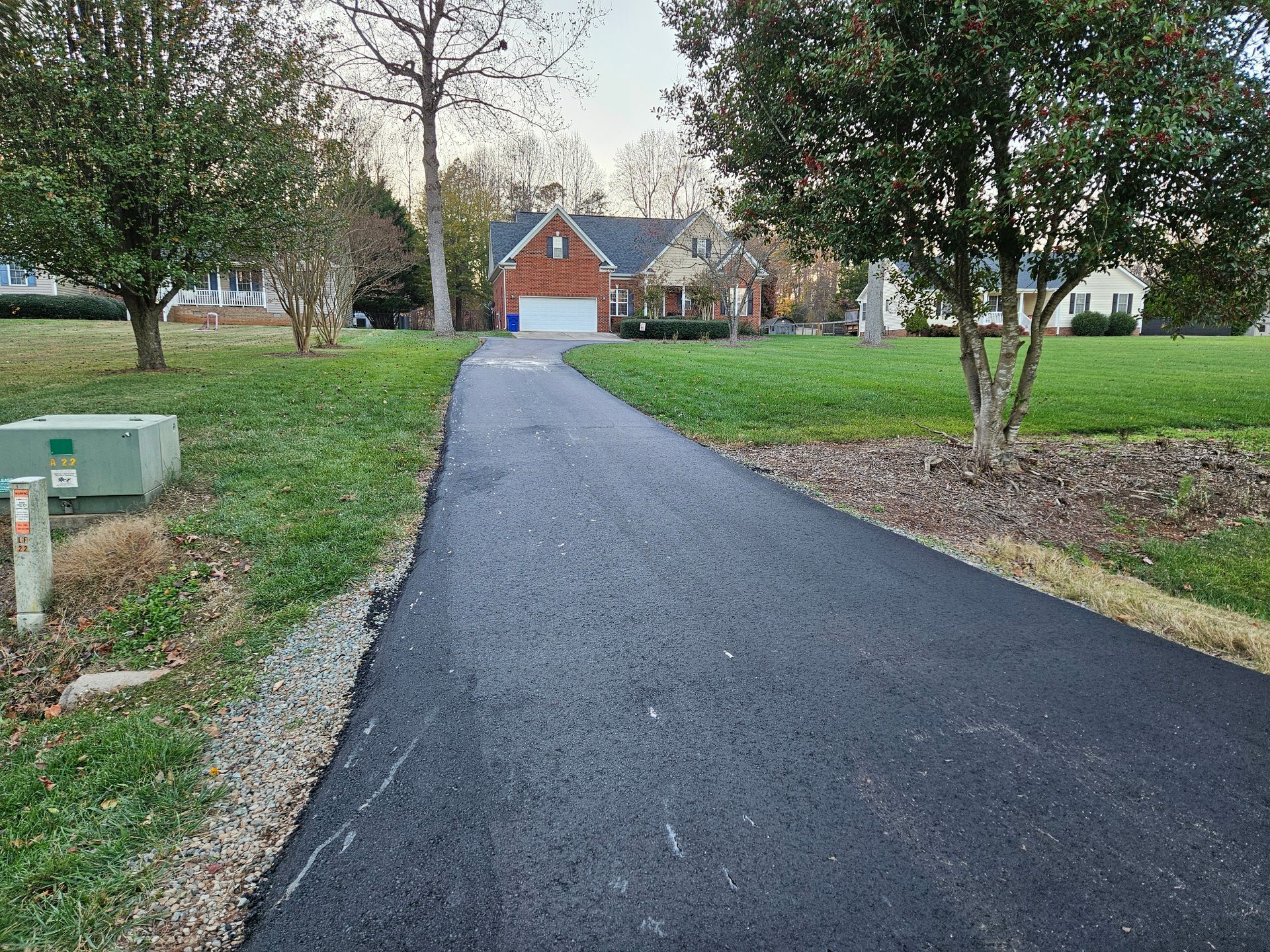 A driveway leading to a house with a red garage door.