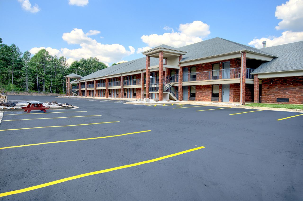 Hotel exterior with brick facade and covered entrance under a blue sky.