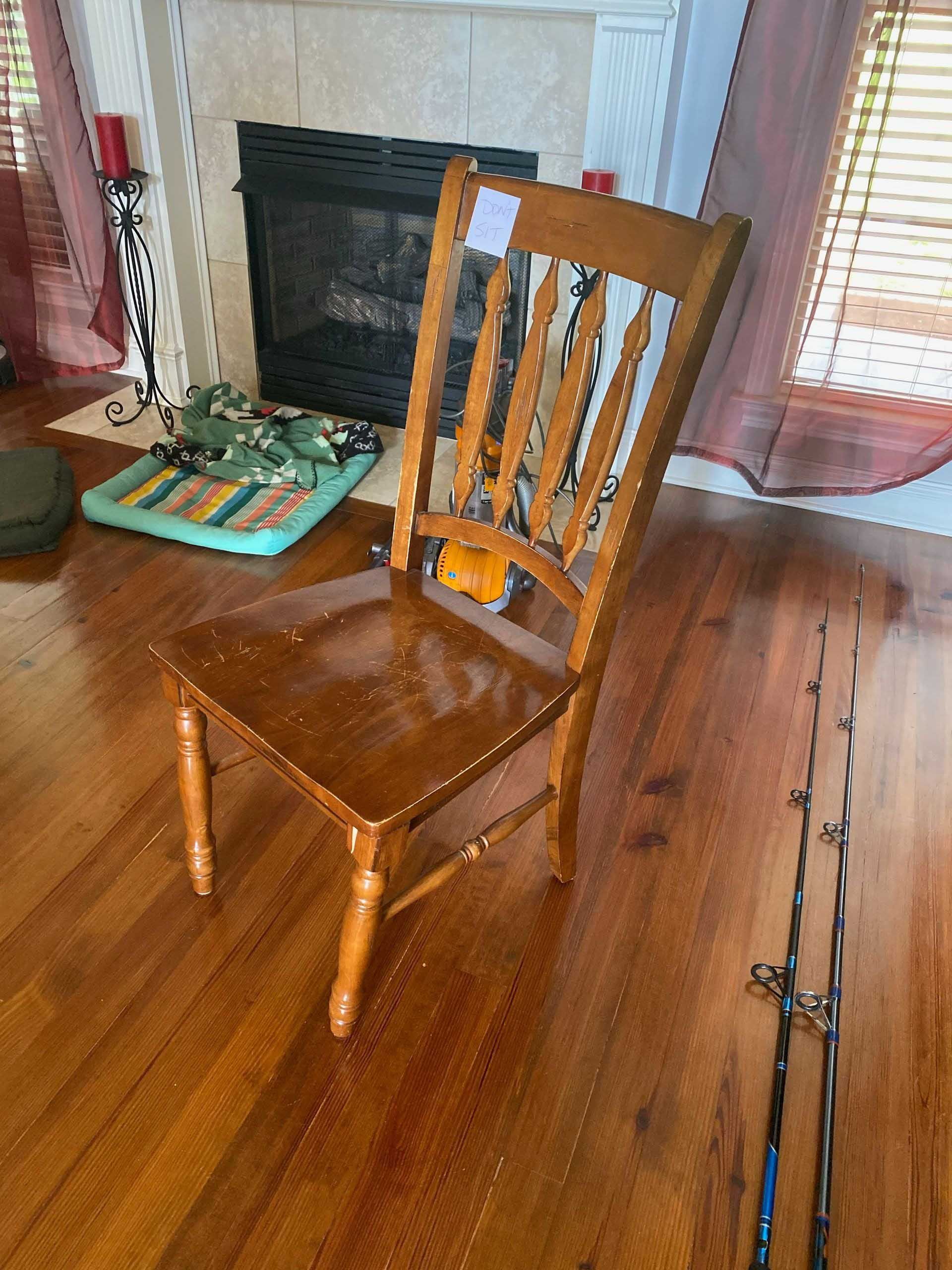 Wooden chair in a room with a fireplace and hardwood floors.