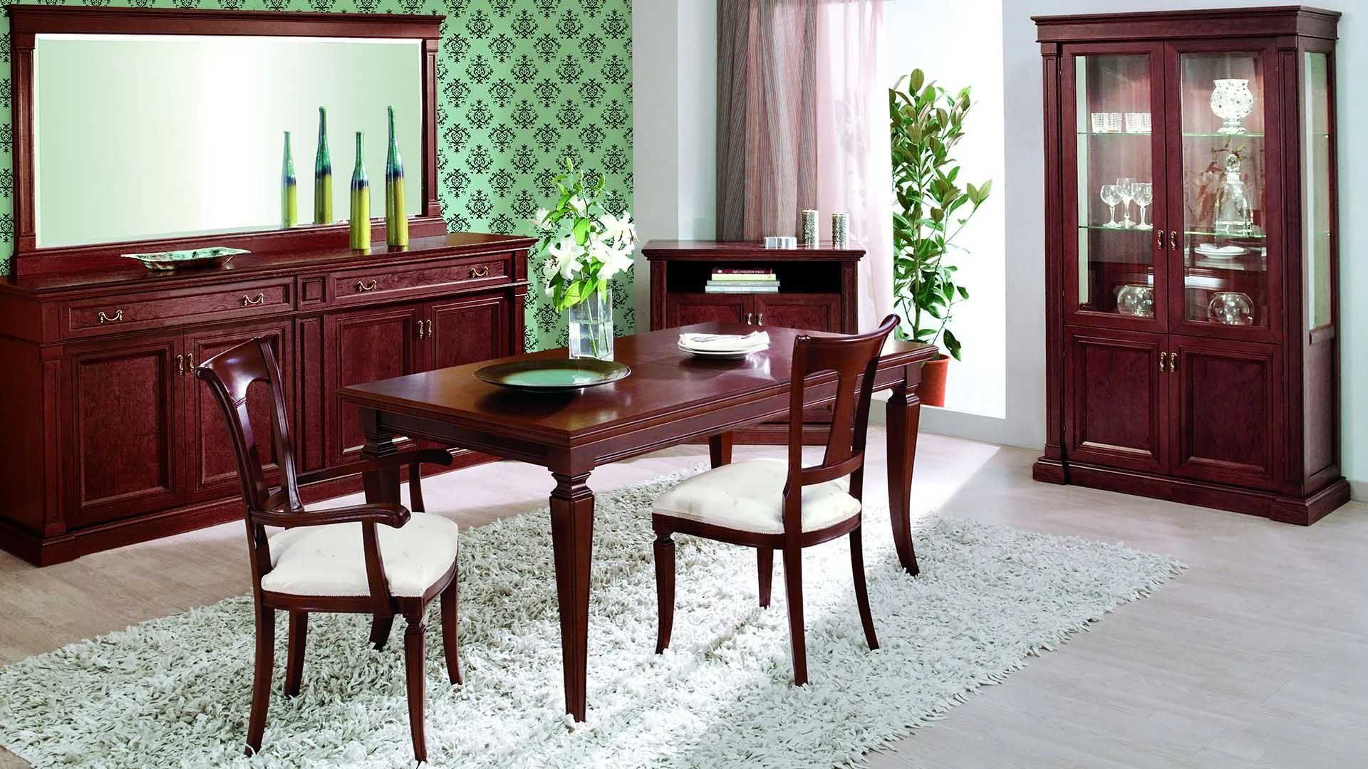 Dining room with dark wood furniture: table, chairs, buffet, and cabinet. White rug, green patterned wallpaper.