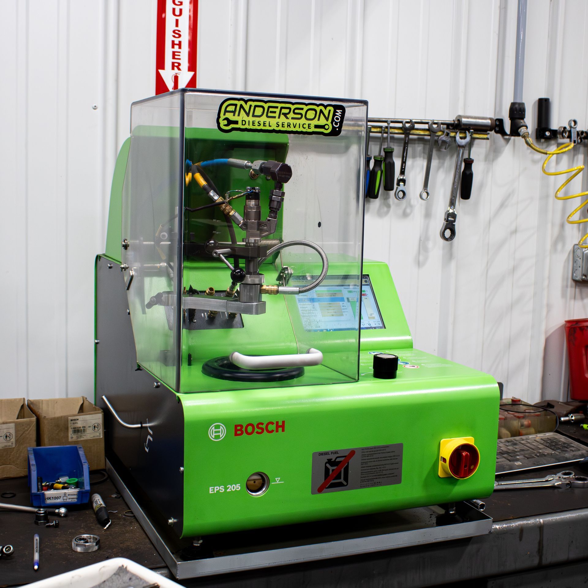 Green Bosch Anderson machine in a workshop, with clear safety cover and control panel.
