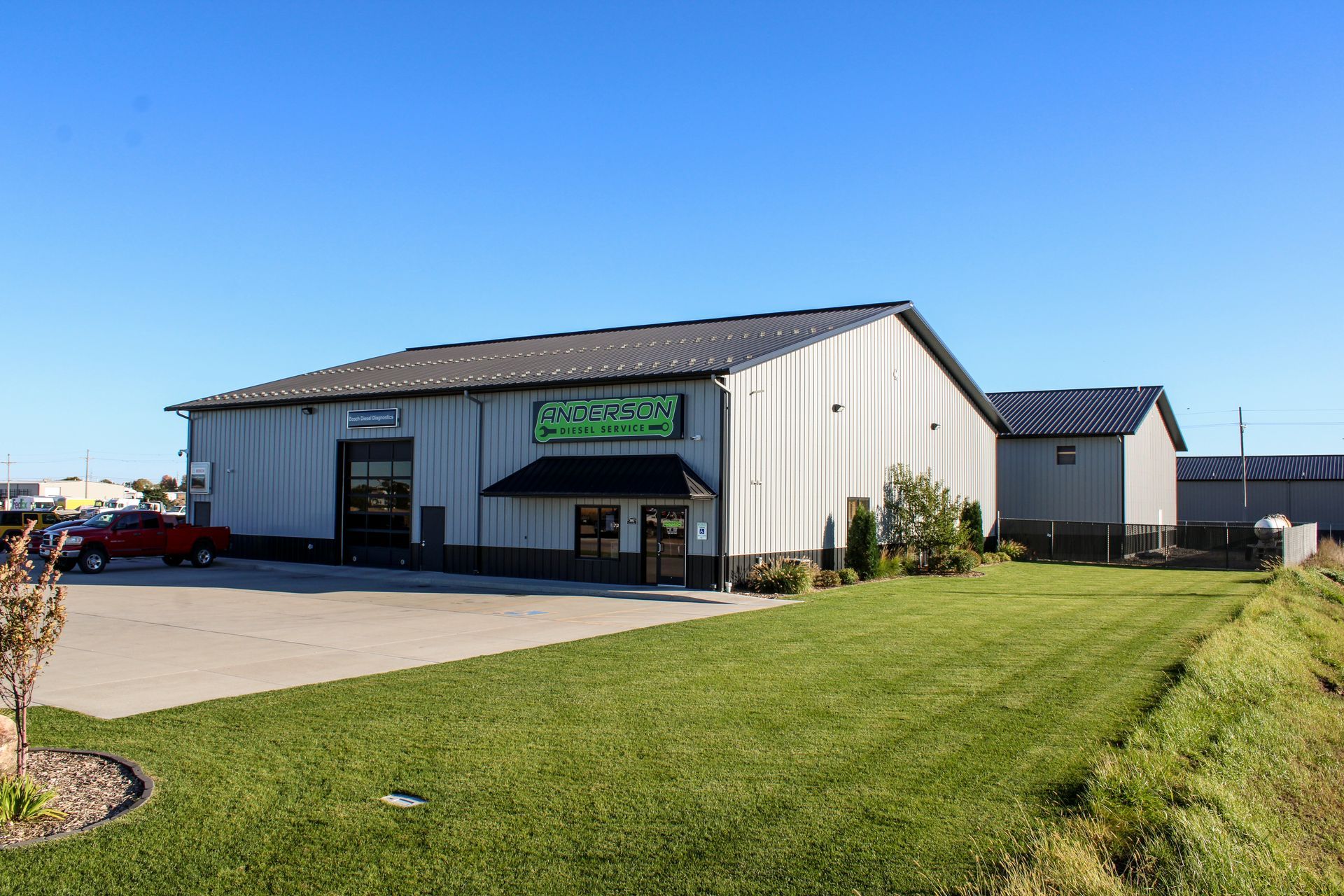 Small commercial building with green lawn and clear blue sky on a sunny day