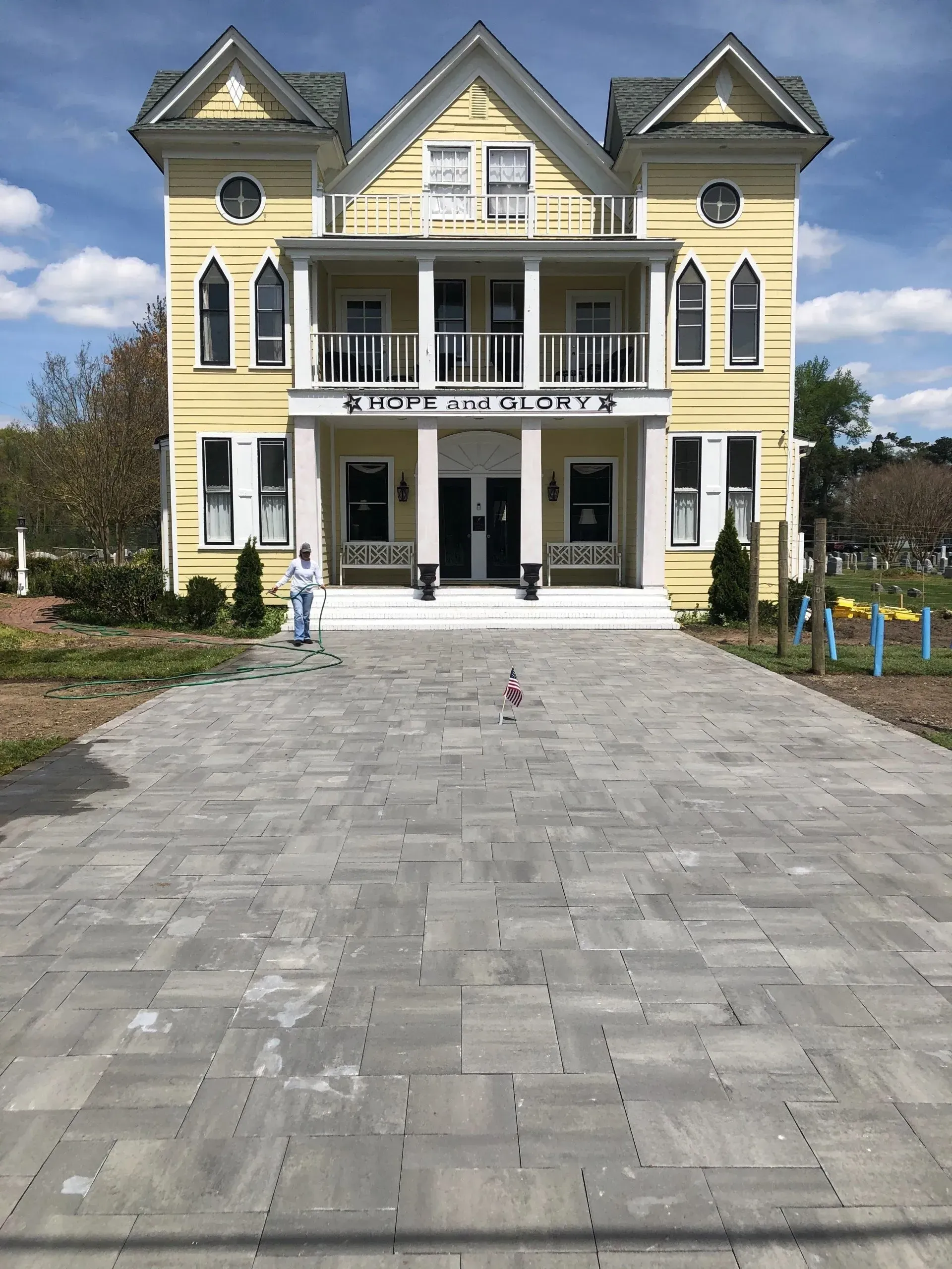 Yellow two-story building with a wide gray paved walkway.