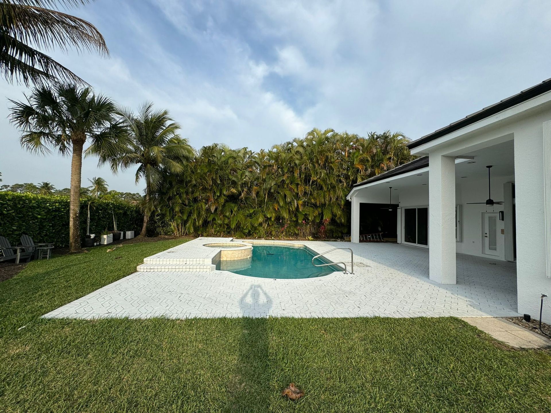 There is a large swimming pool in the backyard of a house.