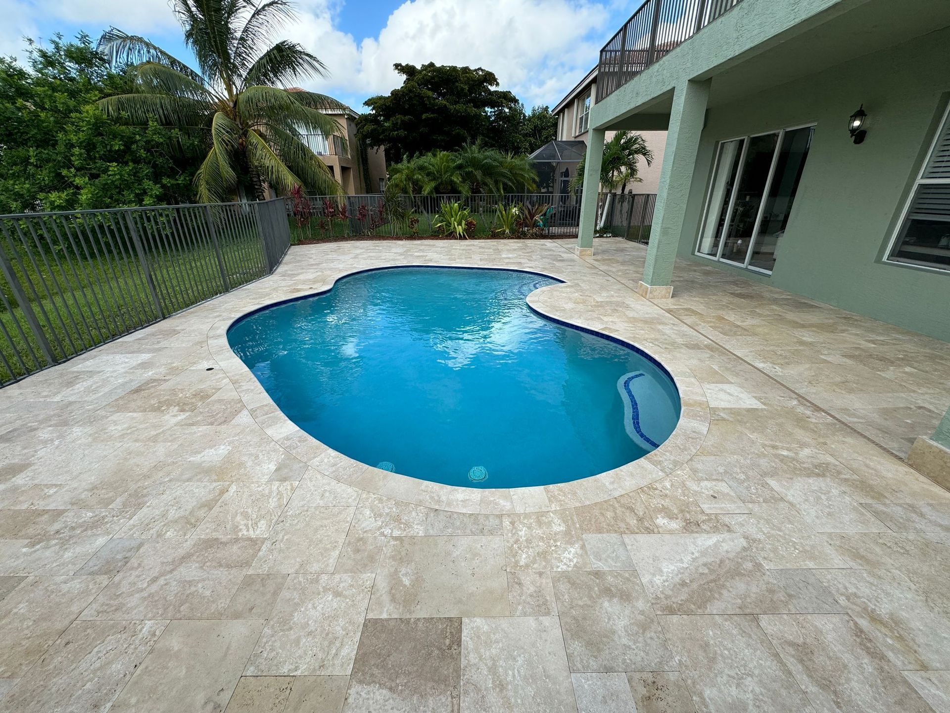 A large swimming pool in the backyard of a house