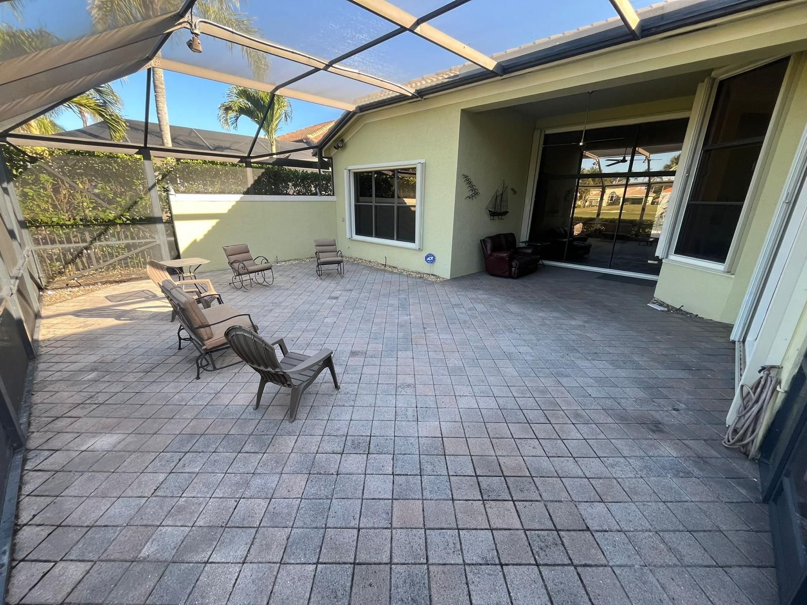 A patio with chairs and a table in front of a house.