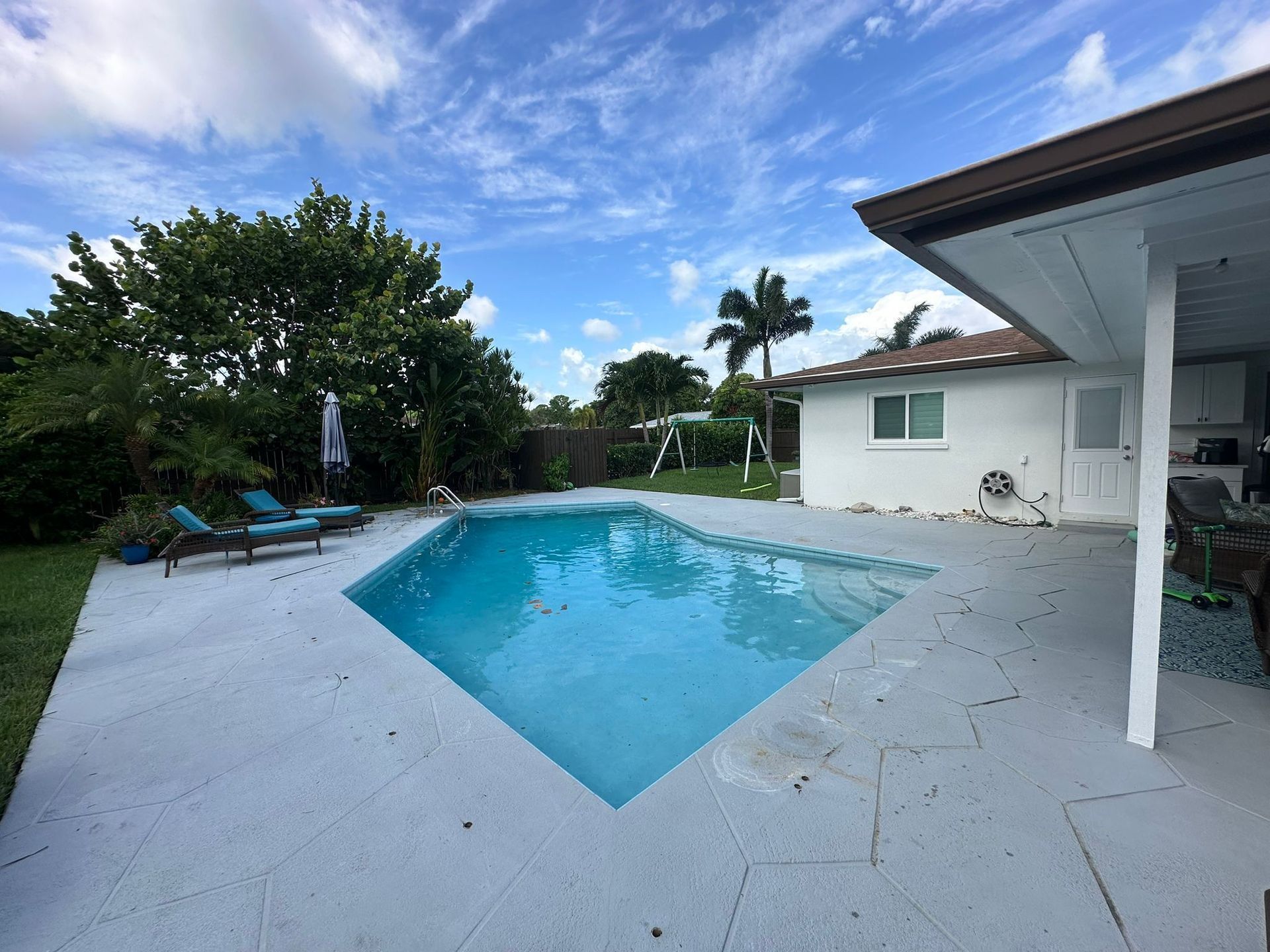 A large swimming pool in the backyard of a house