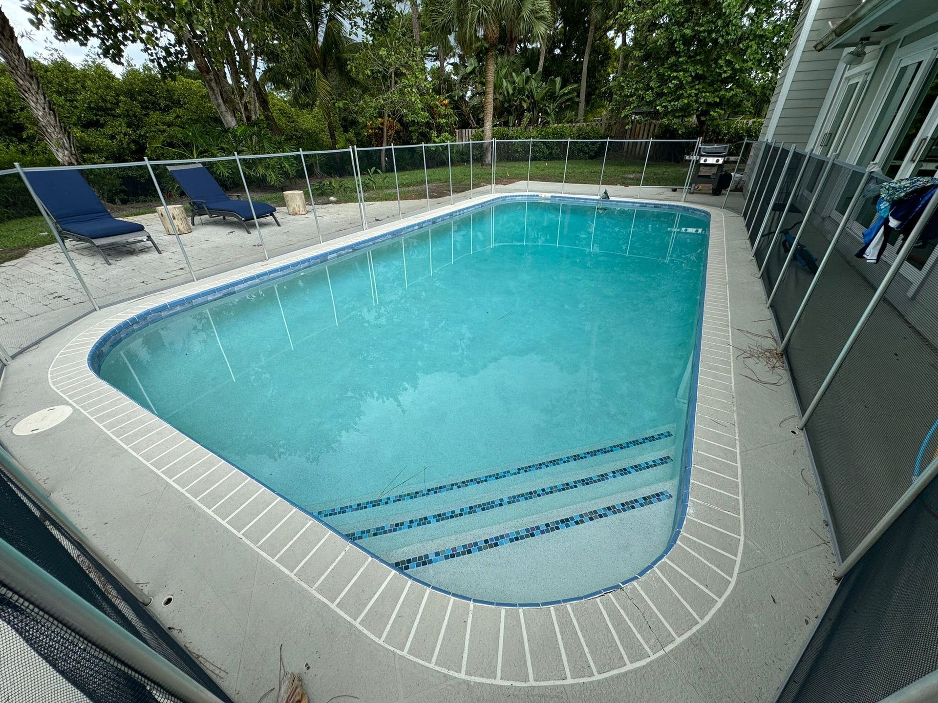 A large swimming pool in the backyard of a house