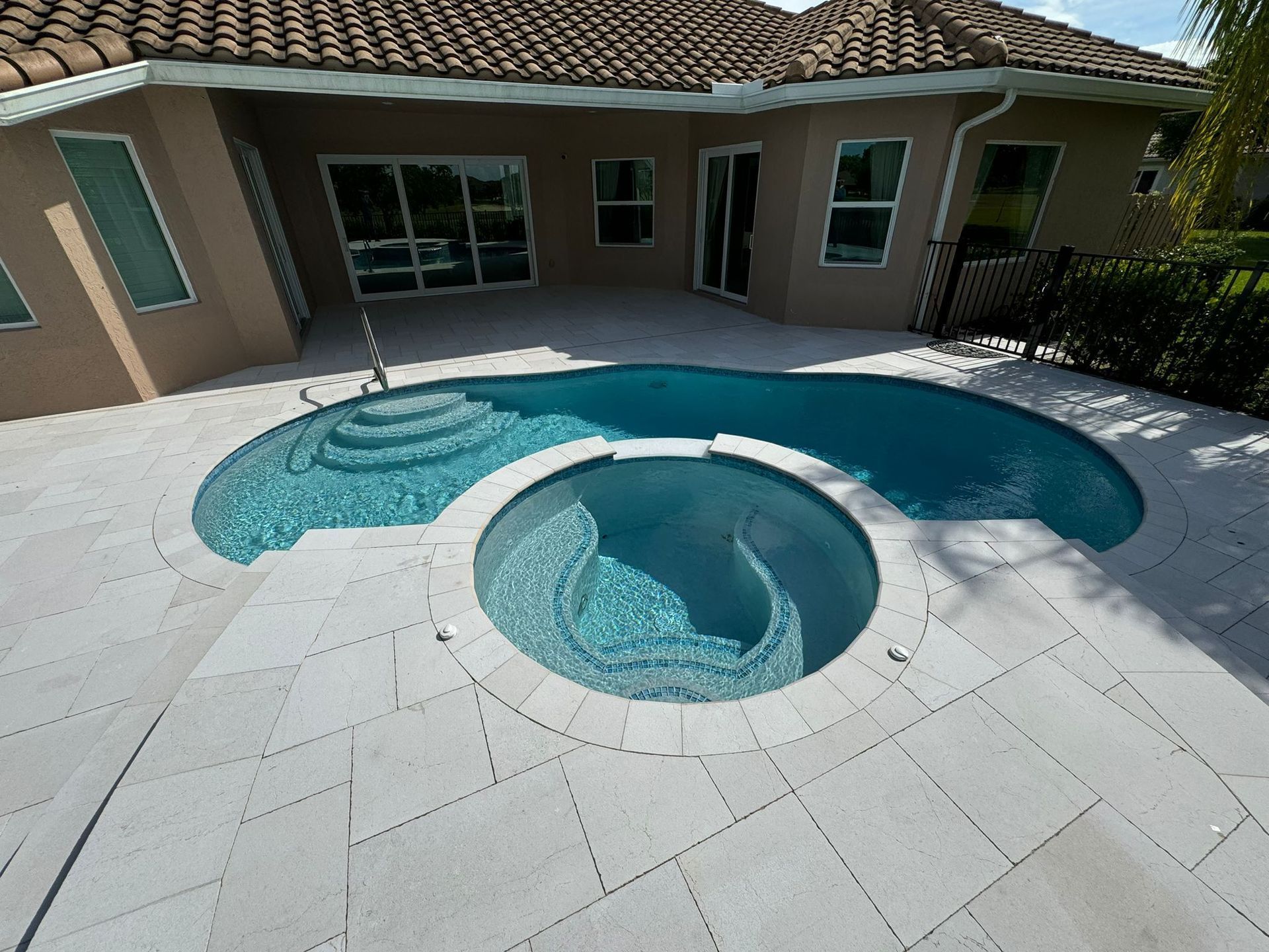 A house with a large swimming pool in front of it