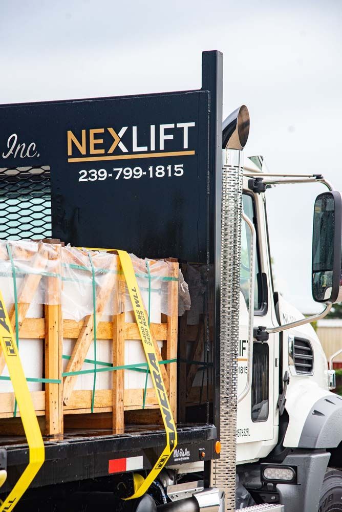 Truck hauling cargo secured with yellow straps.