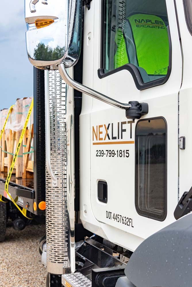 White Nexlift truck with a driver.