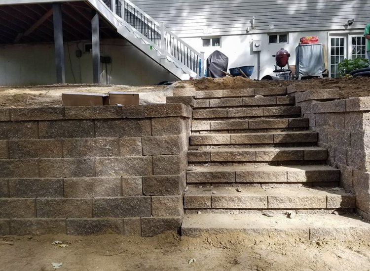 a brick wall with stairs leading up to a house