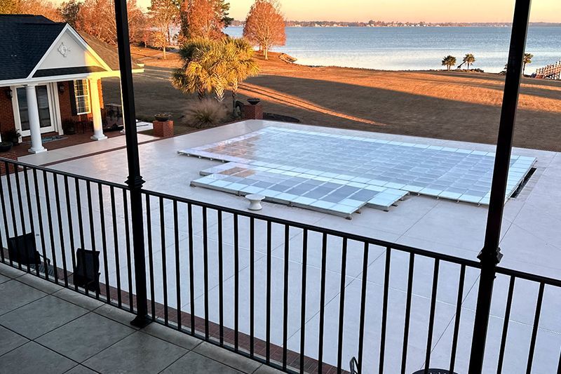 Snow-covered rooftop deck overlooking a beach and calm water at sunset