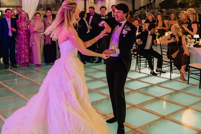 Bride and groom dancing at a wedding reception on a lighted dance floor
