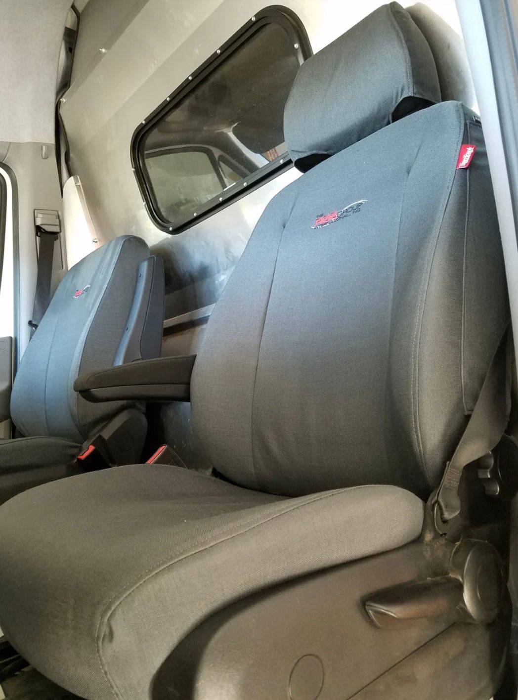 Truck frame on a lift in a garage. Chassis, wheels, engine visible.